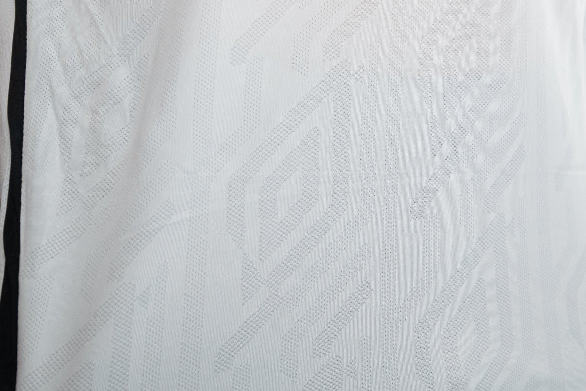 Mønsteret i drakta byggjer på den diamantforma logoen til Umbro!